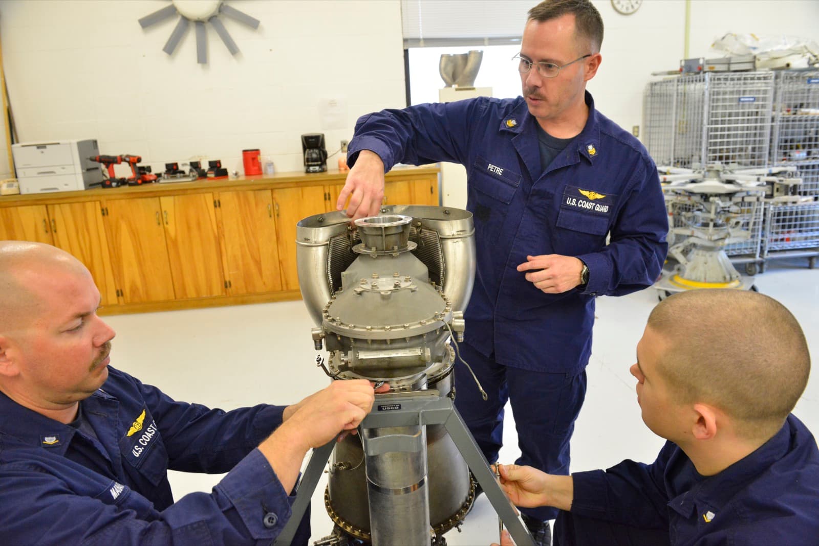 Instructors and trainees working through a turbine engine on a maintenance stand